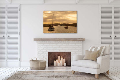 Golden light over Morston Quay creek with boats on calm water