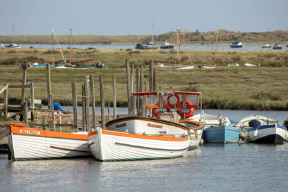 Boats on the creek at Morston Quay with North Norfolk salt marsh in the background