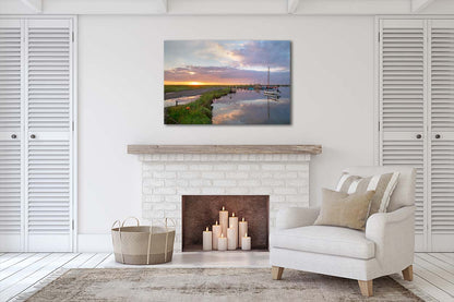 Sunset glow over Morston Quay creek with reflections and boats in the distance