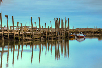 Harbour posts and calm creek reflections at Morston Quay on the Norfolk coast