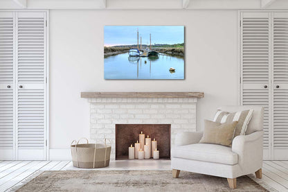 Two boats reflected in calm water at Morston Quay harbour